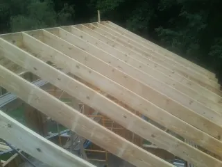 New roof rafters set over an addition before sheathing in Marblehead