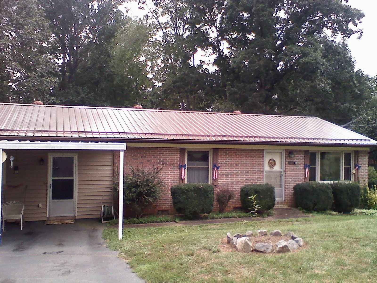 Bronze metal roof and carport on a brick ranch home — Roof Repair work by our crew in Marblehead